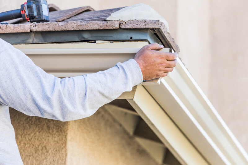 types of gutters, roofing specialist adjusting residential gutters